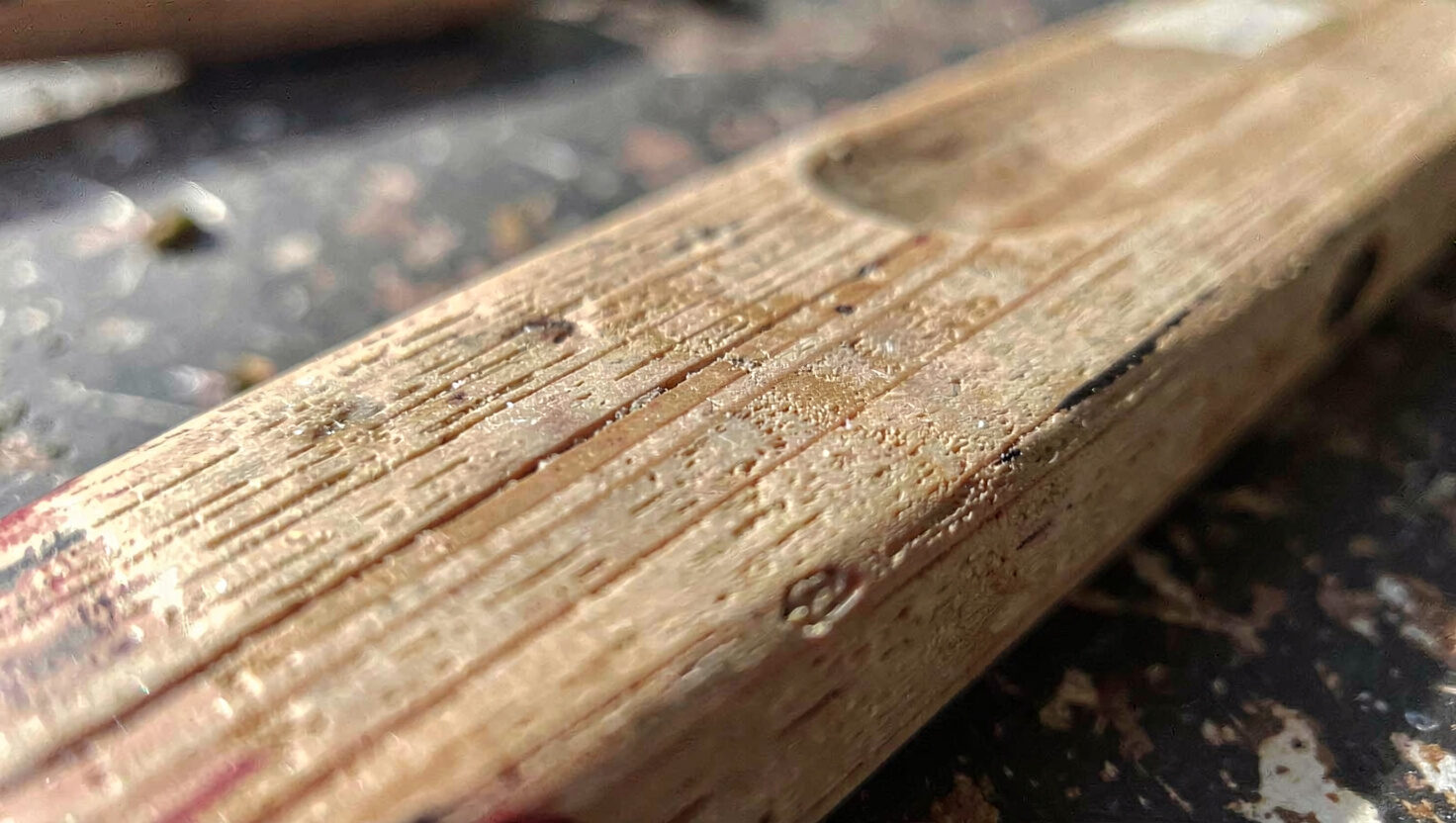 Later pages of a surfcasting glossary beside a pencil, split rings and a small wooden plug